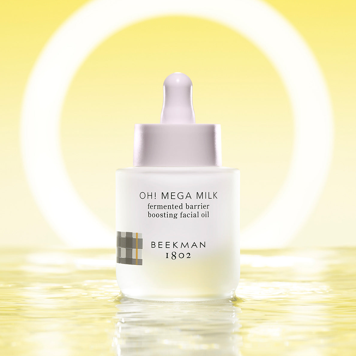 Oh! Mega Milk bottle standing on wet surface in front of o-ring light with yellow background