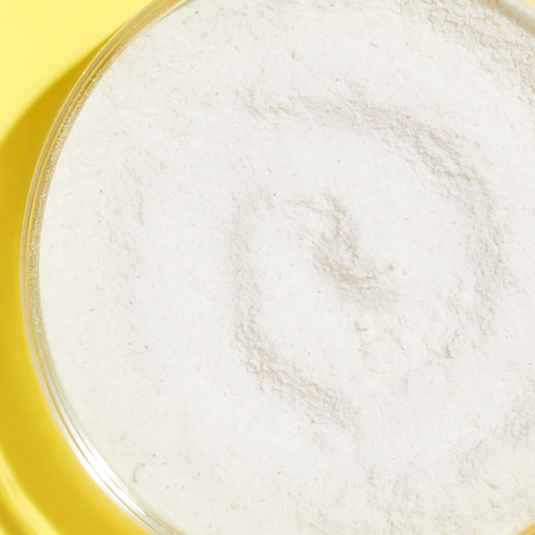 Up close shot of the mineral zinc ingredient inside a petri dish on a yellow background. 